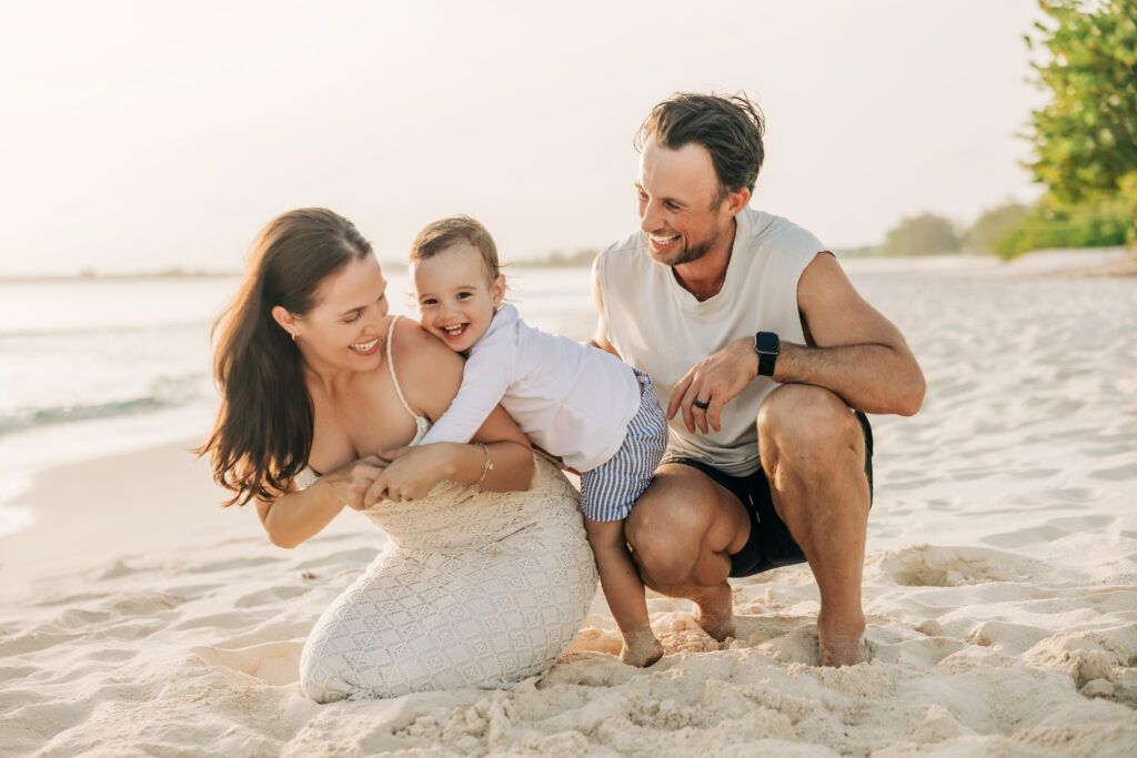 Family of three during a sunset beach session in Grand Cayman