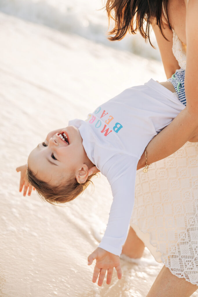 Parents and toddler laughing together on a Cayman beach
