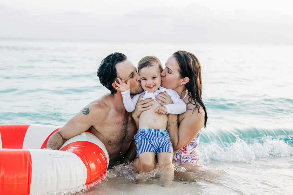 Parents and toddler having fun in the water during their Cayman family photos
